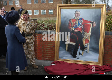 Der Prinz von Wales (zweite links) und die Herzogin von Cornwall (links) enthüllen während eines Besuchs der Basis des 1. Bataillons, Welsh Guards, in Aldershot, Hampshire, ein Gemälde von sich selbst, wo der Prinz von Wales, Oberst des Regiments, dem Bataillon Kampagnenmedaillen überreichte. Stockfoto