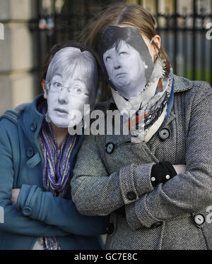 Die Sinn-Fein-Aktivisten Kathryn Reilly und Aine Downes (links) tragen Masken mit den Gesichtern der Regierung, der TDS Mary Hannifin und Mary Harney, während einer Fotoserie, um alle TDS der Fianna Fail und der Grünen Partei aus Dubliner Wahlkreisen hervorzuheben, die heute für Kürzungen des Sozialschutzes stimmen werden Zahlungen. Stockfoto