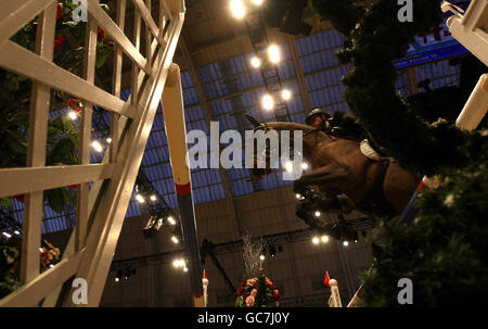 Ein Pferd und Reiter machen sich auf der London International Horse Show im Olympia Exhibition Centre, London, über die Sprünge im Rolex FEI Worldcup Jumping auf. Stockfoto