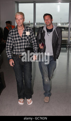 Ich bin ein Celebrity Get me out of here die Teilnehmer Colin McAllister und Justin Ryan kommen zurück am Terminal 3 des Flughafens Heathrow, Middlesex. Stockfoto