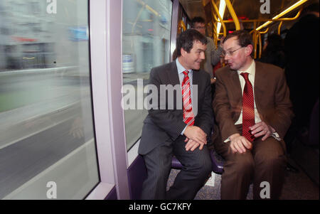 Verkehrsminister Noel Dempsey (links) und Frank Allen, CEO der Railway Procurement Agency, fahren auf der neuen Erweiterung der Luas Docklands, die ab heute von Busaras zum Point Village im Stadtzentrum von Dublin führen wird. Stockfoto