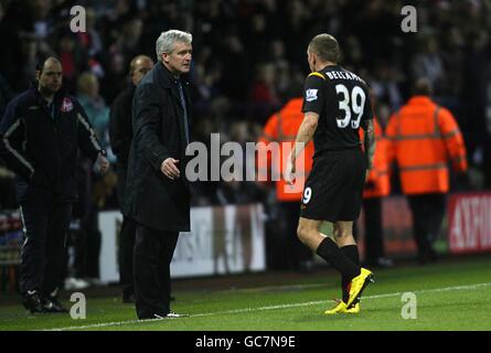 Craig Bellamy von Manchester City (rechts) zeigt seinen Unglauben gegenüber Manager Mark Hughes, nachdem Schiedsrichter Mark Clattenburg eine zweite gelbe Karte gezeigt hatte Stockfoto