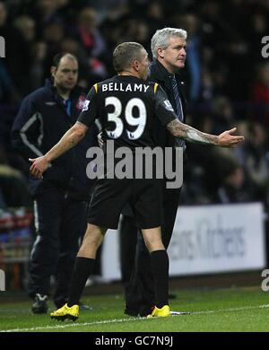 Craig Bellamy (Mitte) von Manchester City zeigt seinen Unglauben gegenüber Manager Mark Hughes, nachdem Schiedsrichter Mark Clattenburg eine zweite gelbe Karte gezeigt hatte Stockfoto