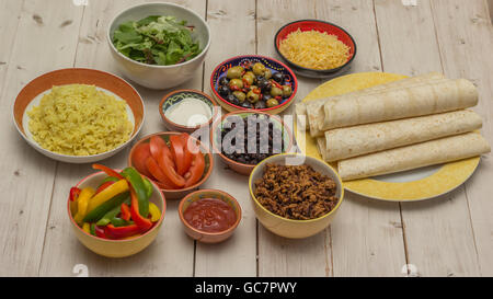 Vielzahl von Zutaten, um mexikanische Burritos mit Tortillas, Reis, Käse, Hackfleisch, Tomaten, schwarzen Bohnen Stockfoto