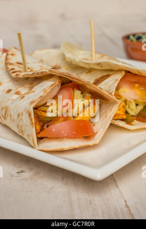 Burritos, gefüllt mit Hühnerfleisch, Paprika, Reis und Tomaten mit Salsa auf der Seite Stockfoto