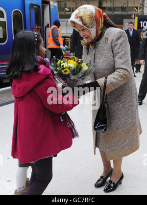 Die britische Königin Elizabeth II. Nimmt eine schicke Blumenpracht entgegen, bevor sie in einen First Capital Connect-Zug fährt, der von der Kings Cross Station in London abfährt, von wo aus sie per Liniendienst nach Kings Lynn in Norfolk fuhr. Später wird sie nach Sandringham reisen, wo sie Weihnachten mit ihrer Familie verbringen wird. Stockfoto