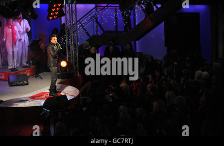 Peter Andre wird ein prominenter Straßenmusiker für den Tag, um Coca Colas Sponsoring der Londoner Sammelplätze zu fördern und Geld für Help a London Child auf dem Spitalfields Market in East London zu sammeln. Stockfoto