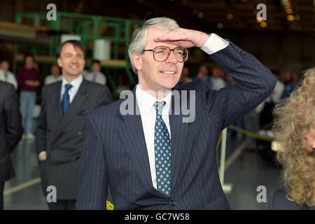 JOHN MAJOR BLICKT IN DIE FERNE, WÄHREND EIN FLUGZEUG VORBEIFLIEGT, WÄHREND ER EIN TORNADO-FLUGZEUG IN DER BRITISCHEN LUFT- UND RAUMFAHRTFABRIK WARTON BETRACHTET. Stockfoto