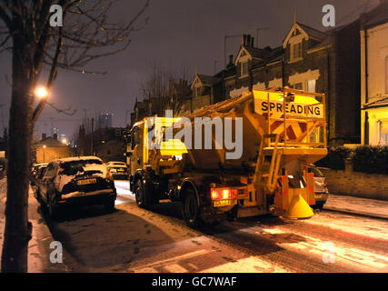 Ein Fahrzeug verteilt Salz als Schnee verursacht Rush Hour Verkehrsprobleme in Wandsworth, London. Stockfoto