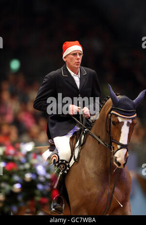 Der niederländische Albert Zoer trägt einen weihnachtshut während der London International Horse Show im Olympia Exhibition Centre, London. Stockfoto