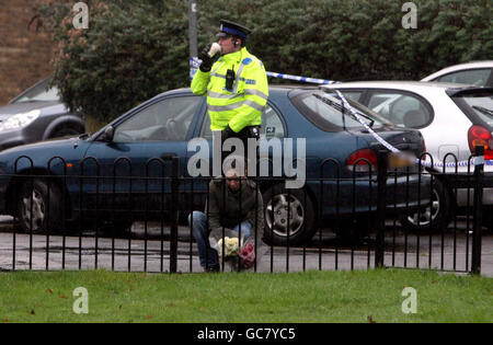 EDS ANMERKUNG: NUMMERNSCHILD VERDECKT DURCH BILDTISCH EINE Frau legt Blumen an der Szene in der Nähe, wo ein vierjähriges Mädchen und ein Mann tot in einem Haus in Aldershot, Hampshire, gefunden wurden. Stockfoto