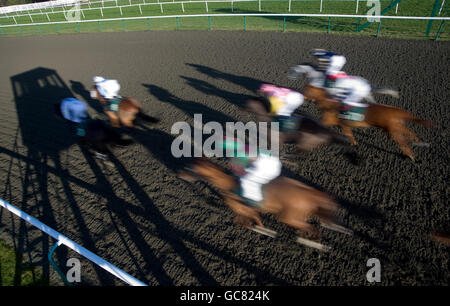 Läufer und Fahrer kommen am Zielpfosten vorbei Bei Lingfield Stockfoto