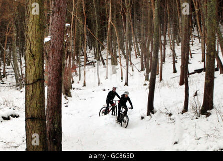 Mountainbiker schaffen es in Innerleithen in den Scottish Borders einen Hügel durch starken Schnee hinunter. Stockfoto