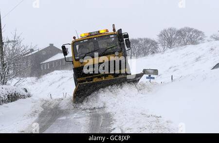 Ein Schneepflug räumt die Straßen rund um die Autobahn M62 im Gebiet Huddersfield frei, da in vielen Gebieten Großbritanniens weiterhin Schnee fällt. Stockfoto