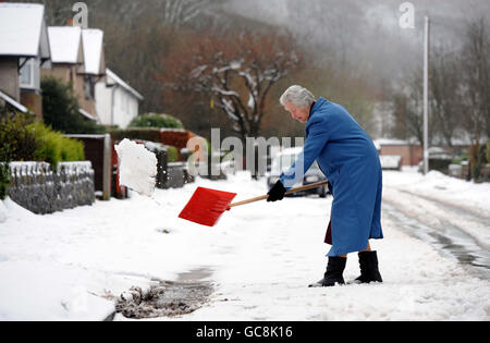 Eine Frau fährt in Buxton, Derbyshire, ab, wo Schneeverwehungen von bis zu vier Fuß Tiefe gemeldet wurden. Stockfoto