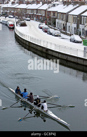 Ruderer machen sich auf den Weg auf den River Cam im Zentrum von Cambridge City, nachdem sie über Nacht einen leichten Schneebefall hatten. Stockfoto