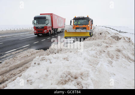 Ein Schneepflug reinigt den auftauenden Schnee auf der A66 in der Grafschaft Durham, die heute wieder eröffnet wurde, nachdem vier Tage lang Schnee gebunden war. Stockfoto