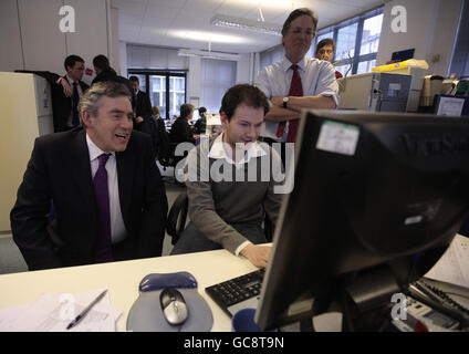 Gordon Brown spricht mit Jamie Sport (Mitte), dem Social Media Office des Britischen Roten Kreuzes, während er die Büros des Katastrophenschutzkomitees im Norden Londons besucht. Stockfoto