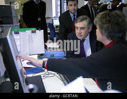 Der internationale Entwicklungsminister Douglas Alexander (links) und Gordon Brown sprechen mit Pat Willson (rechts), dem Manager der Spendenbeschaffung, während eines Besuchs in den Büros des Katastrophenschutzkomitees im Norden Londons. Stockfoto