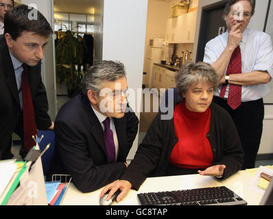 Douglas Alexander (links) und Gordon Brown sprechen mit Pat Willson (2. Rechts), dem Manager für die Spendenbeschaffung, während sie das Katastrophenschutzkomitee im Norden Londons besuchen. Stockfoto