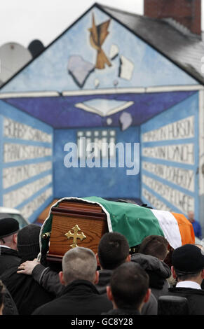 Der Sarg des Derry-Dissidenten Republikaners Jim Gallagher, der in den 1970er Jahren interniert wurde, passiert auf dem Weg zur St. Columbas Church zur Requiem-Messe ein Wandgemälde, das die H-Blöcke in der Bogside-Gegend von Belfast zeigt. Stockfoto