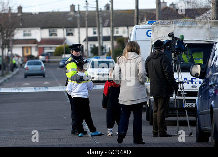 Kinder und Medien sehen sich als ein garda-mans-Cordon an, als gestern Abend um 22.20 Uhr in Coolock, Dublin, ein Mann bei einem Gundland-ähnlichen Schusswaffenangriff getötet wurde. Die Schießerei auf der Ferrycarrig Road in Priorswood ist der vierte Todesfall von 2010 Waffen, nachdem letzte Woche drei Männer bei zwei separaten Angriffen in der Hauptstadt getötet wurden. Stockfoto