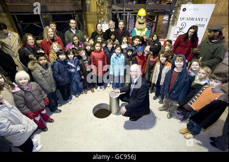 Roger Bright, CEO des Crown Estate, legt eine Zeitkapsel in den Boden des Quadrant 3 Regent Street Entwicklungsstandortes, dem Gelände des ehemaligen Regent Palace Hotels, im Zentrum von London, flankiert von Kindern der Soho Parish School. Stockfoto