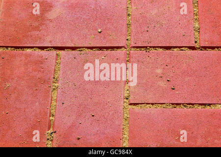rote Betonpflaster Platten mit Sand hautnah Stockfoto