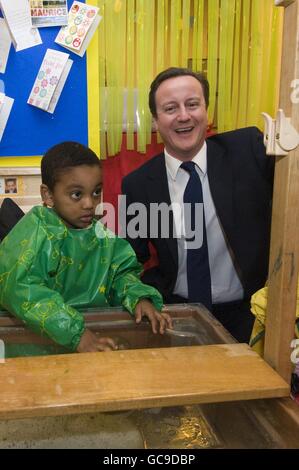 Tory-Führer David Cameron wird mit den 3-jährigen Zwillingen Mubeen und Wuneeb Tingari während eines Besuchs in einer Londoner Kindertagesstätte der Early Years Foundation in London abgebildet. Stockfoto