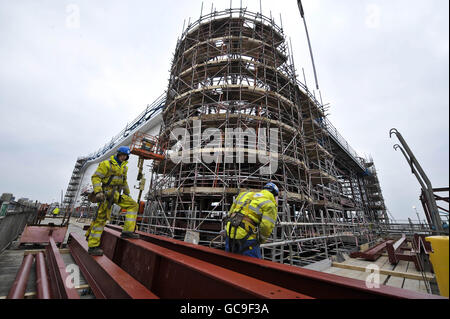 Arbeiter vor dem nordwestlichen Eckturm, Das sich noch im Bau befindet, da die Stahlträger vorbereitet werden, um in Position gebracht zu werden, während die Arbeiten am Grand Pier in Weston-super-Mare in Vorbereitung auf die Fertigstellung und die Wiedereröffnung im Sommer 2010, nachdem es im Juli 2008 durch einen Brand zerstört wurde, fortgesetzt werden. Stockfoto