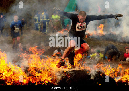 Ein Mann, der beim Tough Guy Competition auf der South Perton Farm in Perton teilnimmt. Stockfoto