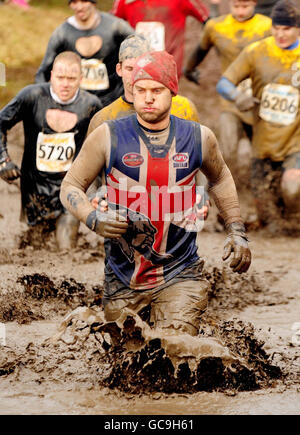 Ein Mann, der beim Tough Guy Competition auf der South Perton Farm in Perton teilnimmt. Stockfoto