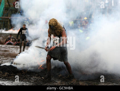 Ein Konkurrent in ausgefallenen Kleid konkurriert in der Tough Guy Stockfoto