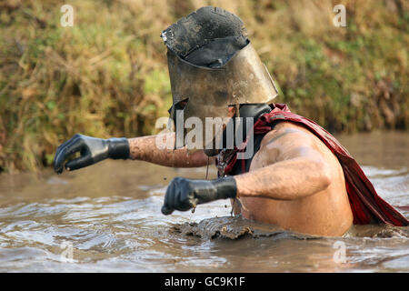 Ein Wettbewerbskleid in ausgefallener Kleidung wagt während des Sumpfes durch den Sumpf Tough Guy Stockfoto