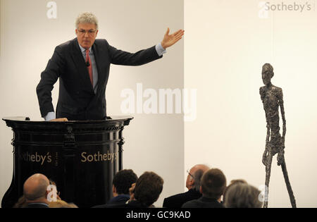 Der Auktionator Henry Wyndam verkauft die Skulptur Walking man oder L'Homme qui marche I von Alberto Giacometti in Sothebys Londoner Auktionsräumen für über 65 Millionen Pfund. Stockfoto