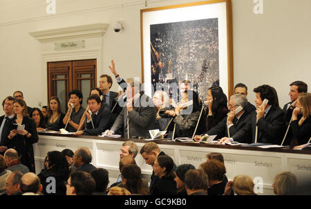 Die Mitarbeiter nehmen Telefonangebote an, da der Auktionator Henry Wyndam die Skulptur Walking man oder L'Homme qui marche I von Alberto Giacometti in Sothebys Londoner Auktionsräumen verkauft. Stockfoto