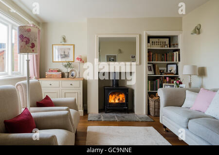 Gemütliche Hütte Wohnzimmer mit Holzofen und Leinen gepolstertes sofa Stockfoto