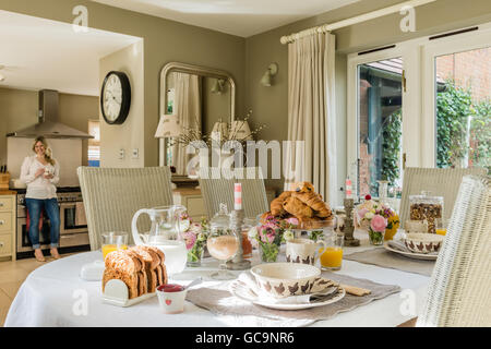 Tisch gedeckt mit Frühstück Croissant und Toast. Die Esszimmerstühle sind Fulham Lloyd und Webstuhl. Stockfoto