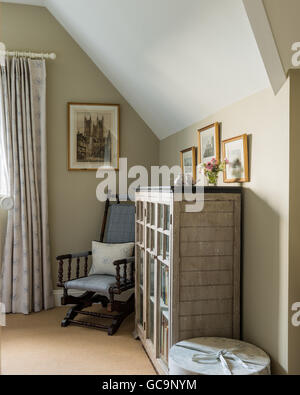 Antiker Schaukelstuhl in Tweed von Pfingstrose & weisen neben Glas fronted Bücherregal gepolstert Stockfoto