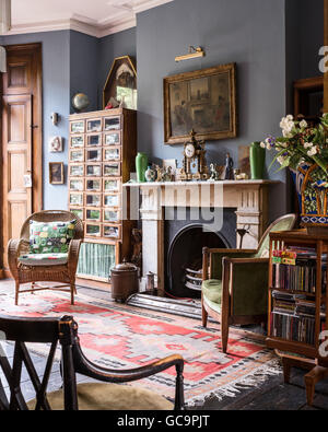 Arts And Crafts Stil drehbaren Bücherschrank mit der 1930er Jahre Tuchmacher und Kolonialstil Stuhl in Nottinghill Salon, London, U Stockfoto