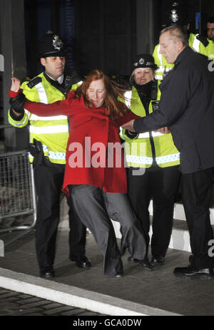 Die Protestantin Grace McCann wird von der Polizei vor dem Queen Elizabeth II Conference Center in London zurückgehalten, nachdem der frühere Premierminister Tony Blair vor der Irakuntersuchung aufstand. Stockfoto