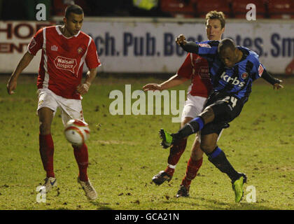 Kyel Reid von Charlton Athletic schießt beim Tor, nachdem er die Walsall-Verteidiger Jamie Vincent (rechts) und Netan Sansara (links) während des Coca-Cola Football League One-Spiels im Banks Stadium, Walsall, besiegt hatte. Stockfoto