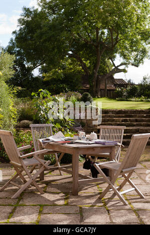 Gartenmöbel von Andrew Crace in Massanfertigung gepflastert Gartenbereich mit erhöhten Rasen. Stockfoto