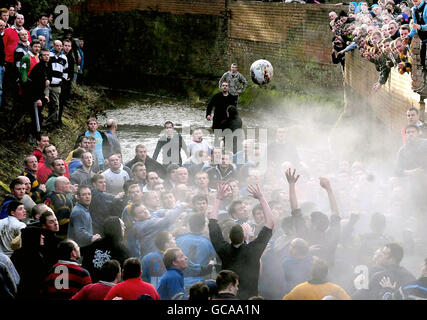 Die Teilnehmer spielen beim Ashbourne Shrovetide Fußballspiel in Ashbourne, Derbyshire. Stockfoto