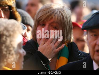 Ein Fan von Manchester United trägt einen gelben und grünen Schal Wirkt emotional außerhalb von Old Trafford vor dem Start Als Manchester United Rememeber den 52. Jahrestag der München Luftkatastrophe Stockfoto