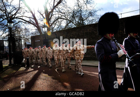 Mitglieder der Queen's Own Yeomanry, der Royal Mercian und Lancastrian Yeomanry, Royal Signals und Royal Electrical and Mechanical Engineers marschieren durch die Tore des Clarence House, bevor sie vom Prince of Wales im Zentrum von London mit Afghanistan Service Medals überreicht werden. Stockfoto