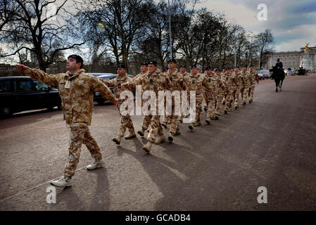 Mitglieder der Queen's Own Yeomanry, der Royal Mercian und Lancastrian Yeomanry, Royal Signals und Royal Electrical and Mechanical Engineers marschieren die Mall entlang, bevor sie vom Prince of Wales im Garten des Clarence House in London mit Afghanistan Service Medals überreicht werden. Stockfoto