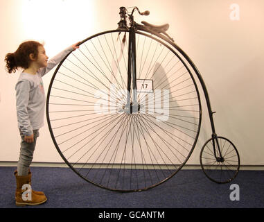 Ein Besucher (Name nicht angegeben) schaut sich einen Penny Farthing aus dem Jahr 1880 an, der Teil des Bonhams Verkaufs von Pioneer, Vintage und Collectors Motorcycles im RAF Museum Hendon, Nord-London, ist. Stockfoto