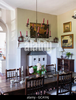 18. Jahrhundert Eiche Tisch und Yorkshire Stühle im Speisesaal mit Terrakotta-Böden und decken Leuchter Stockfoto