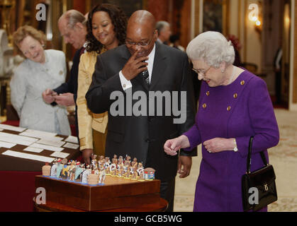 Die britische Königin Elizabeth II., der Herzog von Edinburgh und der südafrikanische Präsident Jacob Zuma und seine Frau Tobeka Madiba Zuma (dritte rechts) betrachten ein Schachspiel, das Nelson Mandela 1996 dem Herzog von Edinburgh gegeben hat, Teil einer Ausstellung südafrikanischer Gegenstände im Buckingham Palace in London. Stockfoto